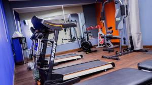 a gym with several tread machines in a room at Aranjuez Hotel & Suites in David
