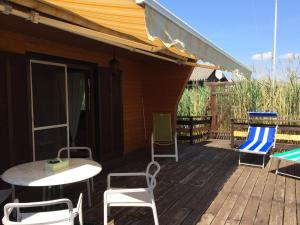 a deck with chairs and a table and chairs at Pfahlbau in Weiden am See in Weiden am See