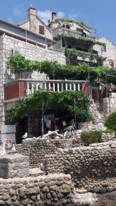 a building with a stone wall in front of it at Anka's Beach in Komiža