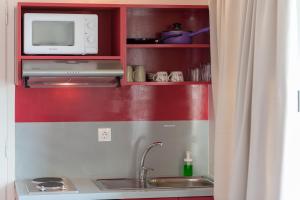 a kitchen with a sink and a microwave at CHROMA Lodge Pikermi in Pikérmion +55 photos