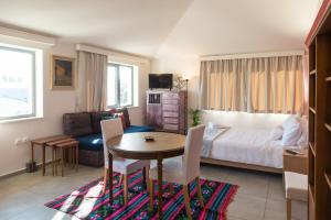 a bedroom with a bed and a table and chairs at CHROMA Lodge Pikermi in Pikérmion