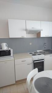 a kitchen with white cabinets and a stove top oven at Guest house Ivanka in Hvar