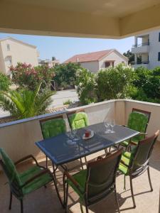 a blue table with green chairs on a patio at Apartment Vesna in Novalja
