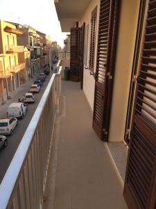 un balcón de un edificio con coches aparcados en la calle en sweet pozzallo, en Pozzallo