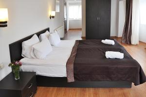 1 dormitorio con 1 cama grande y 2 toallas. en Hotel Corner, en Tiflis