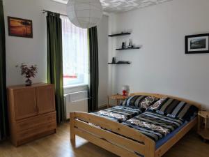 ブロウモフにあるUbytování Janinaのベッドルーム1室(ベッド1台、ドレッサー、窓付)