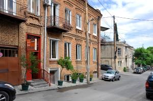 un edificio de ladrillo con un coche aparcado en una calle en Hotel Corner en Tiflis