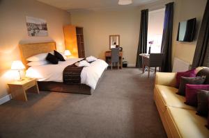 a hotel room with a bed and a couch at Schiehallion Hotel in Aberfeldy