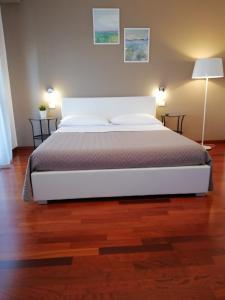 a bedroom with a white bed and a wooden floor at B&B Giulio Cesare in Vasto