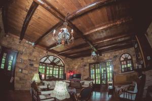 a living room with a stone wall and a chandelier at Kalogirou Stone House in Limnionas