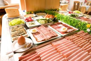 Pension Drei-Mäderl-Haus في Unterlamm: بوفيه من المأكولات مع اللحوم والخضار على الطاولة