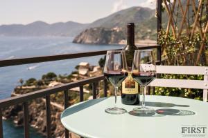 a bottle of wine and two glasses on a table at Il Sogno di Manarola by The First in Manarola