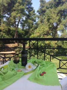 un tavolo con una bottiglia di vino e un fiore sopra di Villa Elani a Kassandra (Kassandria)
