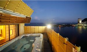 a hot tub on the balcony of a building at Atami Tamanoyu Hotel in Atami