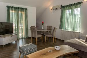 een woonkamer met een tafel en een bank bij Apartmani Mendula in Budva