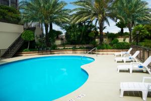 a swimming pool with lounge chairs and palm trees at iStay Hotel Monterrey Histórico in Monterrey