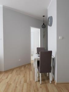 a white dining room with a table and chairs at Apartament Grottgera in Kłodzko