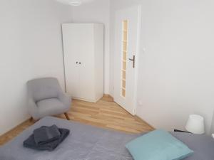 a room with a bed and a chair and a door at Apartament Grottgera in Kłodzko