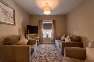 ein Wohnzimmer mit 2 Sofas und einem Fenster in der Unterkunft Diamond House Apartments in Derry Londonderry