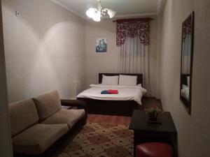 uma sala de estar com uma cama e um sofá em Tumar em Bishkek