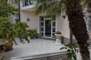 a front porch of a house with a palm tree at Vdl Luxury Villa in Floridia