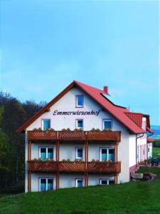 un grand bâtiment blanc avec un toit rouge dans l'établissement Panorama Gasthof Stemler, à Eulenbis