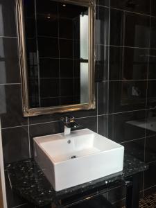 a bathroom with a white sink and a mirror at Halvard Hotel in Douglas