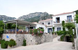 uma casa branca com uma parede de pedra em Avra Hotel em Kyparíssion