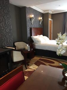a bedroom with a bed and a chair and a table at Halvard Hotel in Douglas