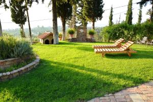 two wooden benches sitting in the grass in a yard at Sea View Villa with 4 bedrooms - grECOrama in Monodhéndrion