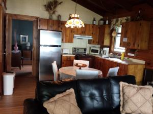 a kitchen and living room with a couch and a table at Motel Le Charentais in Sorel