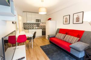 uma sala de estar com um sofá vermelho e uma cozinha em Casa Oliveira in Downtown Porto II em Porto