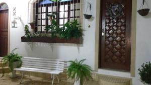 een veranda met een bank en een raam met planten bij London House in São José