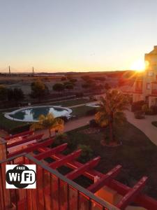 - Vistas a la puesta de sol de un parque con piscina y un edificio en Costa Esuri, Albatros Golf 1 Ayamonte, en Ayamonte