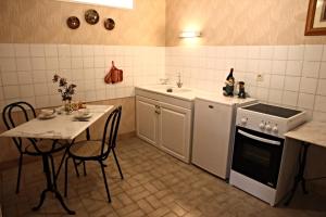 eine Küche mit einem Tisch, einer Spüle und einem Herd in der Unterkunft The Storyteller Apartment at Chateau Le Mur in Carentoir