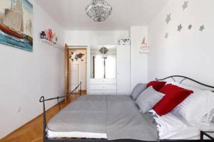 sypialnia z łóżkiem z białymi i czerwonymi poduszkami w obiekcie Zebra w Hvarze