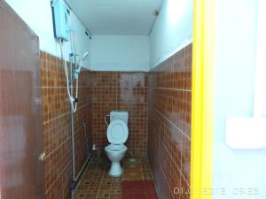 a white toilet sitting in a bathroom next to a wall at RL Budget Rooms in Pantai Cenang