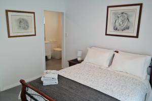 - une chambre avec un lit et deux photos sur le mur dans l'établissement Just triggin, à Perth