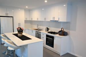 a kitchen with white cabinets and a counter with flowers at Just triggin in Perth
