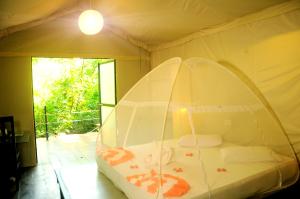 a bedroom with a bed in a tent at Kottawatta Village in Udawalawe