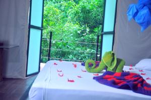 a bed in a room with a window with a bedspread at Kottawatta Village in Udawalawe