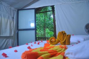 a bed with two stuffed animals sitting on top of it at Kottawatta Village in Udawalawe