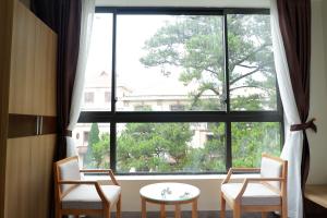 a room with a large window with chairs and a table at Anh Duc Hotel in Tam Ðảo