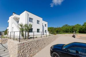 a black car parked in front of a white building at Apartments Residence Romance in Pinezici