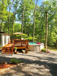 un patio trasero con una piscina, una mesa y una casa en Pocono cabin with private pool at Shawnee Mtn en East Stroudsburg
