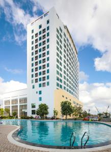 um edifício com piscina em frente a um edifício em Muong Thanh Luxury Ca Mau Hotel em Cà Mau