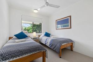 a bedroom with two beds and a window at Le Court Villas in Noosa Heads +104 photos