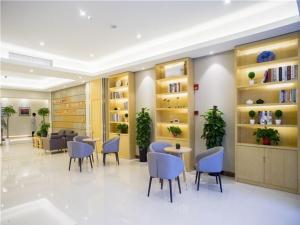 a waiting room with blue chairs and tables and shelves at GreenTree Inn Suzhou Kunshan Dongcheng Road International Exhibition Express Hotel in Penglang