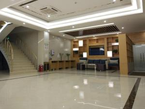a large lobby with a staircase and a waiting room at GreenTree Inn Jinzhong Yuci District North Huitong Road Express Hotel in Jinzhong