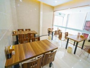 ein Zimmer mit Holztischen und -stühlen in einem Restaurant in der Unterkunft GreenTree Inn Suzhou Mudu Lingyan Mountain Ganglong City Hotel in Suzhou